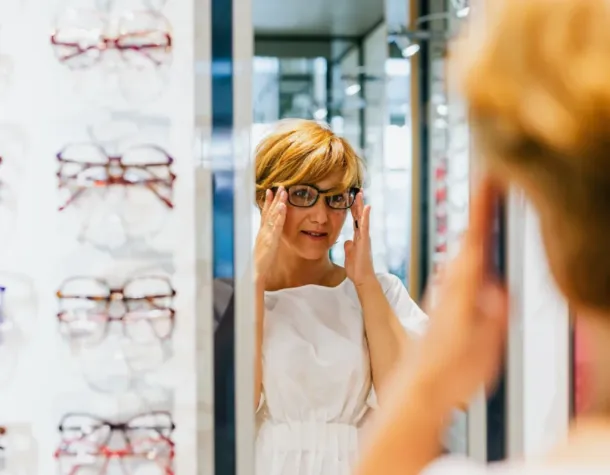 woman in optical shop trying glasses 